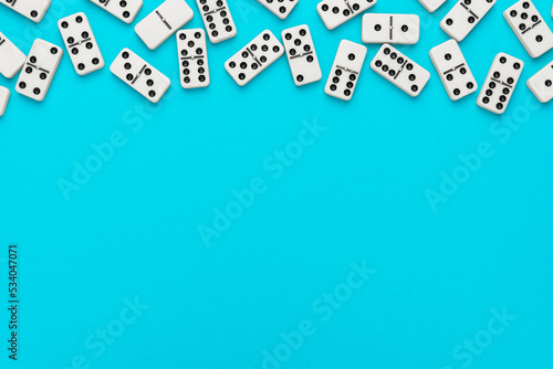 Domino pieces on turquoise blue background with copy space. Flat lay minimalist photo of some domino bones. photo