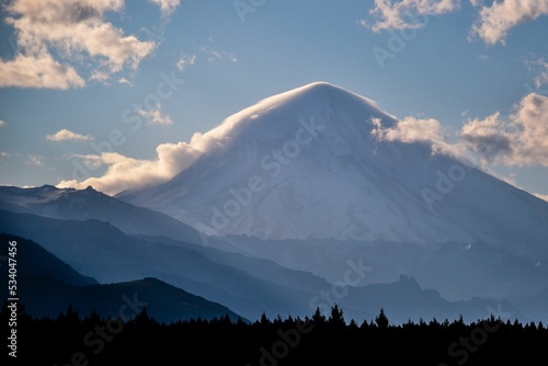 Beautiful landscape displaying the ice-clad, cone shaped Lanin stratovolcano surrounded by clouds photo