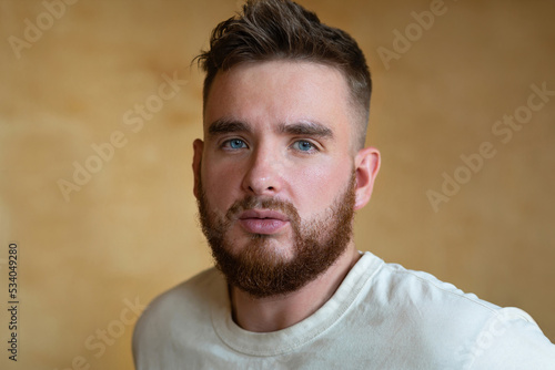 Portrait brutal handsome bearded man with blue eyes, male personal self care, products, accessory for growth style dark brown red beard. Lifestyle people