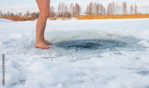 Winter swimming. A woman in a hole in a frozen lake. Recovery and extreme swimmers in ice water.