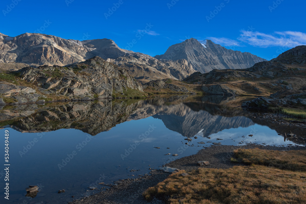 the beautiful reflection of the surrounding mountains in the waters of the Bellecombe lake in the Vanoise massif in the French Alps