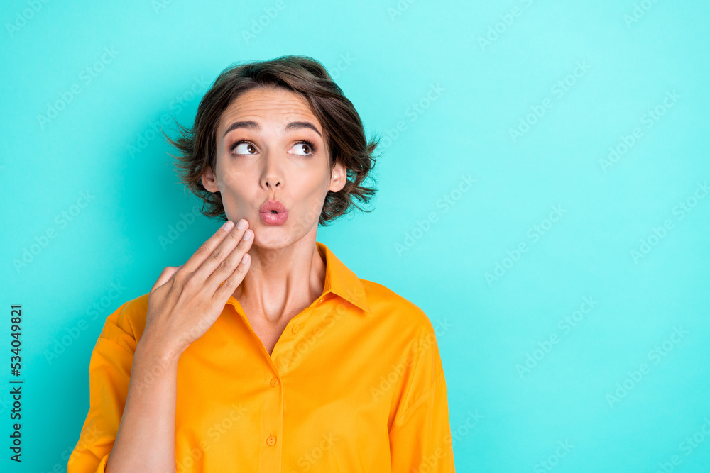 Photo of gorgeous impressed staring girl bob hairstyle dressed yellow shirt look empty space palm cheeks isolated on teal color background Photo of gorgeous impressed staring girl bob hairstyle dressed yellow shirt look empty space palm cheeks isolated on teal color background
