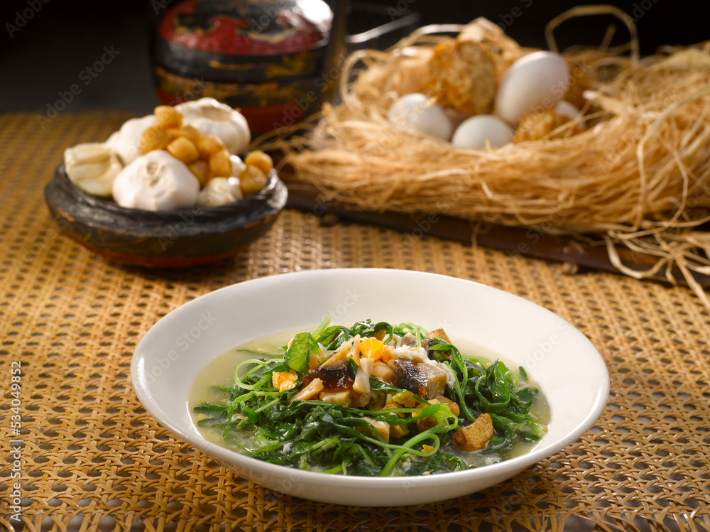 Poached Baby Spinach with Conpoy in Century Egg Salted Egg served in a dish isolated on table side view Poached Baby Spinach with Conpoy in Century Egg Salted Egg served in a dish isolated on table side view