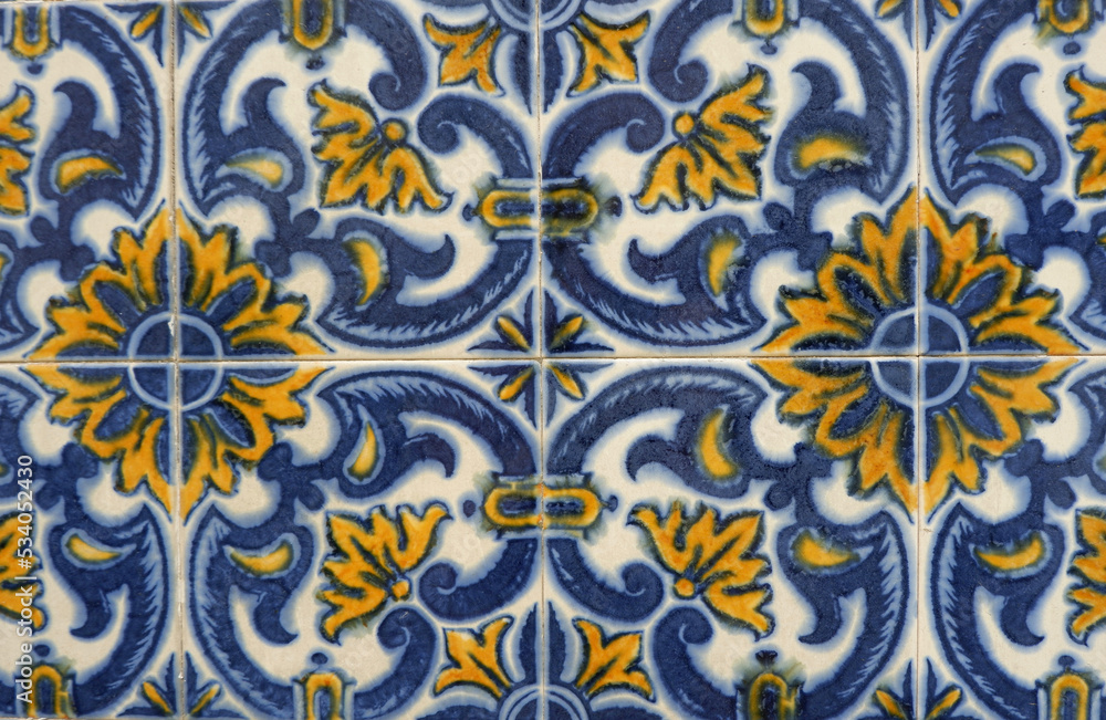 Colourful ceramic tiles with floral ornate in blue and yellow colours outside in Lisbon, Portugal Colourful ceramic tiles with floral ornate in blue and yellow colours outside in Lisbon, Portugal