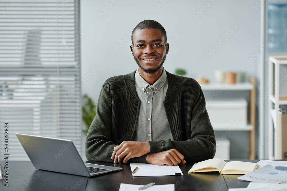 Fototapeta premium Front view portrait of young black man smiling at camera in job interview