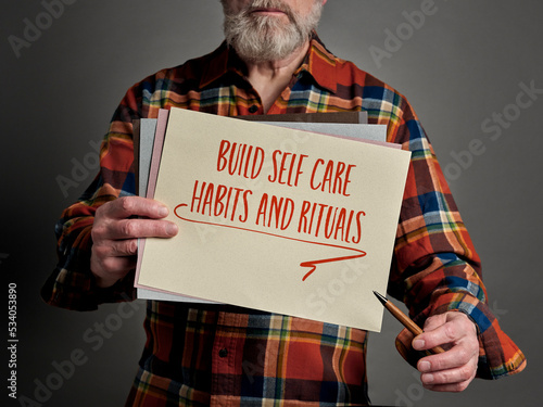 build self care habits and rituals inspirational reminder and advice - handwriting on a paper held by a senior man, physical and mental health and personal development concept photo