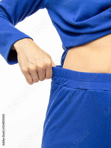 Blue knitted suit on white background. Knitwear noodles viscose. Clothing for sports or sleep. Elastic band on pants