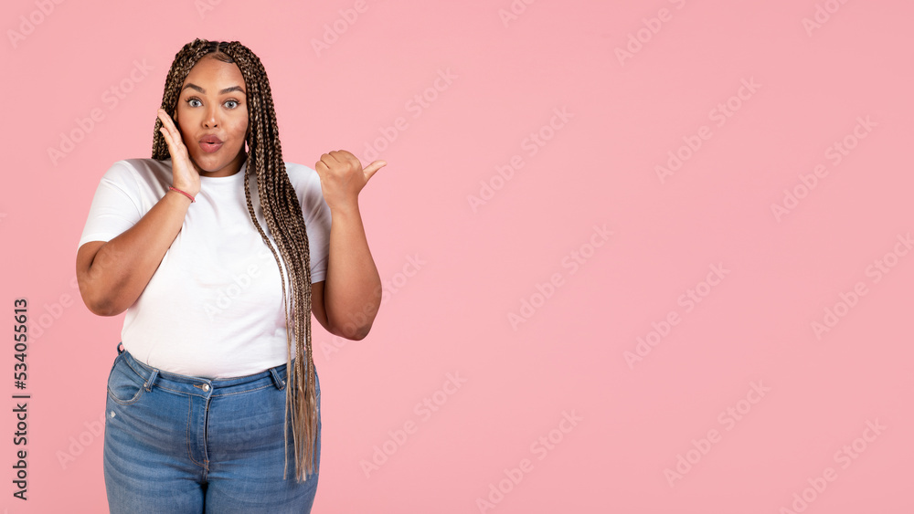 Amazed Black Woman Pointing Thumb Finger Aside On Pink Background Amazed Black Woman Pointing Thumb Finger Aside On Pink Background