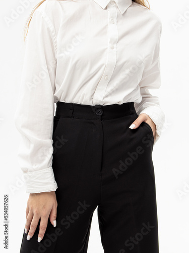 Women's black trousers on white background. Woman in pants and white shirt. Clothes for work, college or school. Comfortable pockets