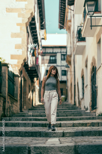 woman walking down a stone staircase street