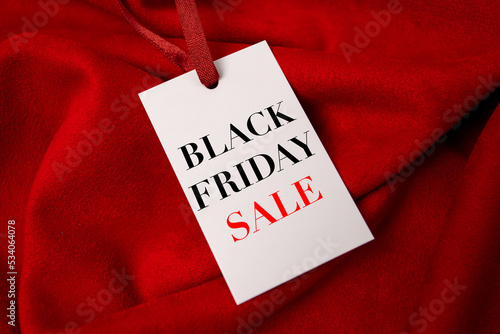 Black Friday sale shopping text on tablet screen on red fabric background.Sale promotion poster. Discount, sale season.