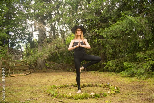 Happy woman in witch costume practicing yoga