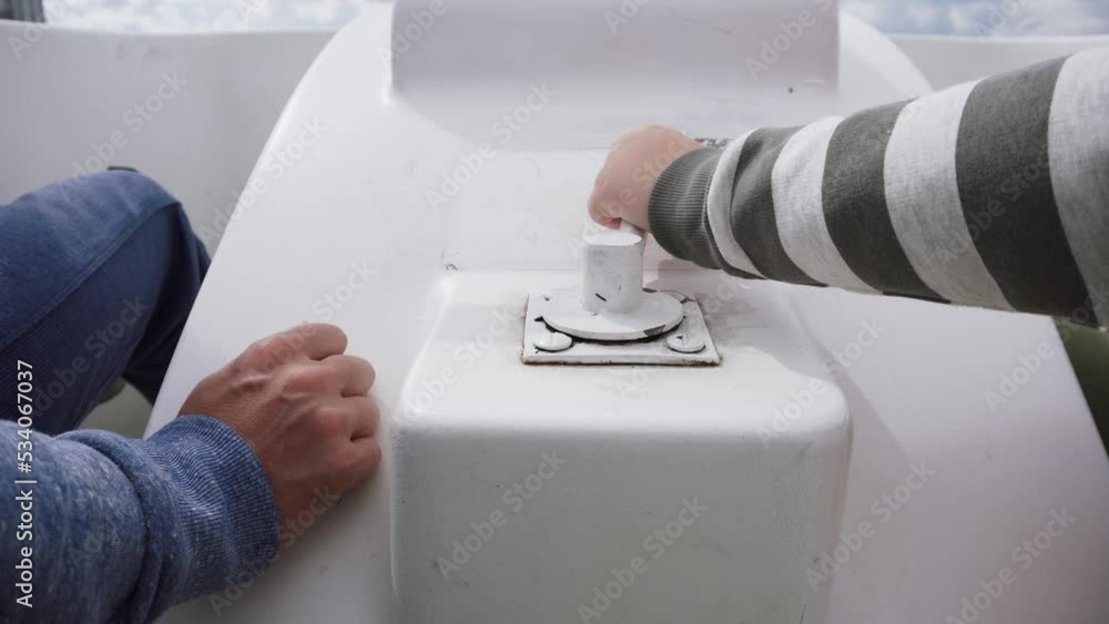 Dad and son turn white lever on pedal boat with hands, close-up. Dad and son turn white lever on pedal boat with hands, close-up.
