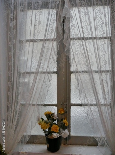 Gardinen und Kunstblumen vor dem Fenster © Clarini