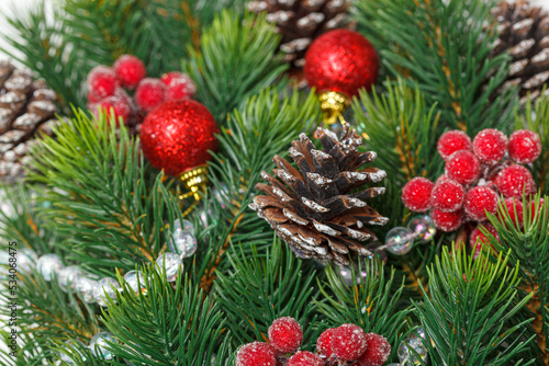Christmas composition  Christmas tree branch with toys  cones on a wooden background