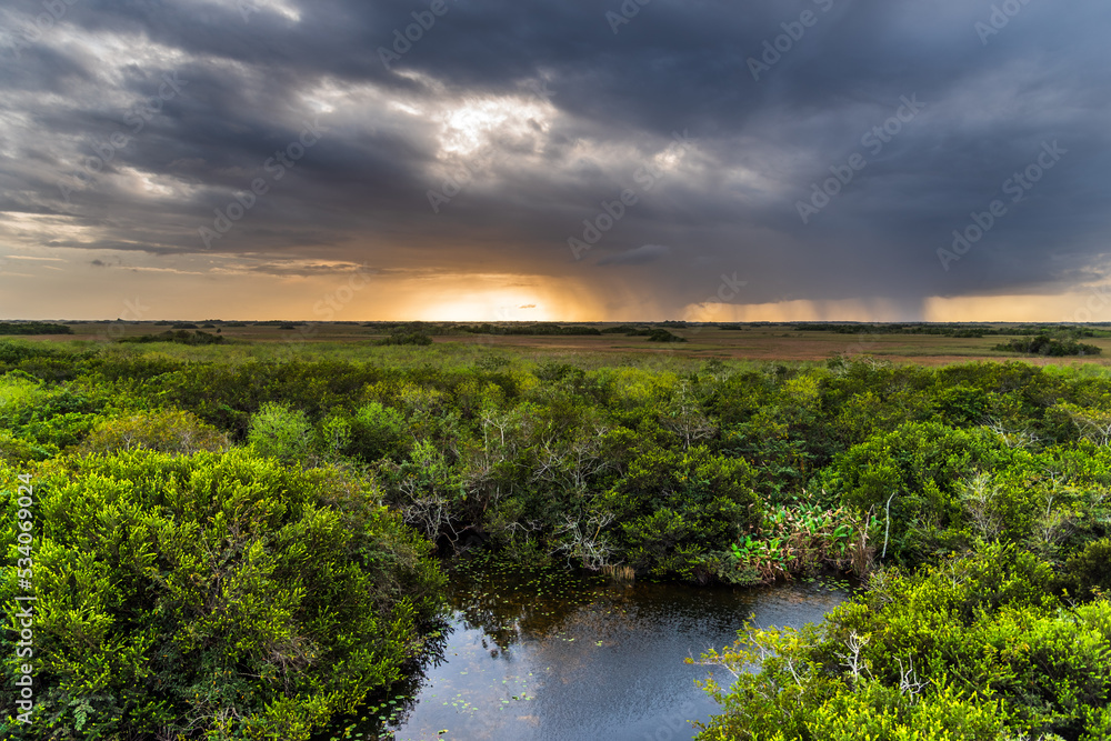 A view towards a distant rainstorm at sunset over the 