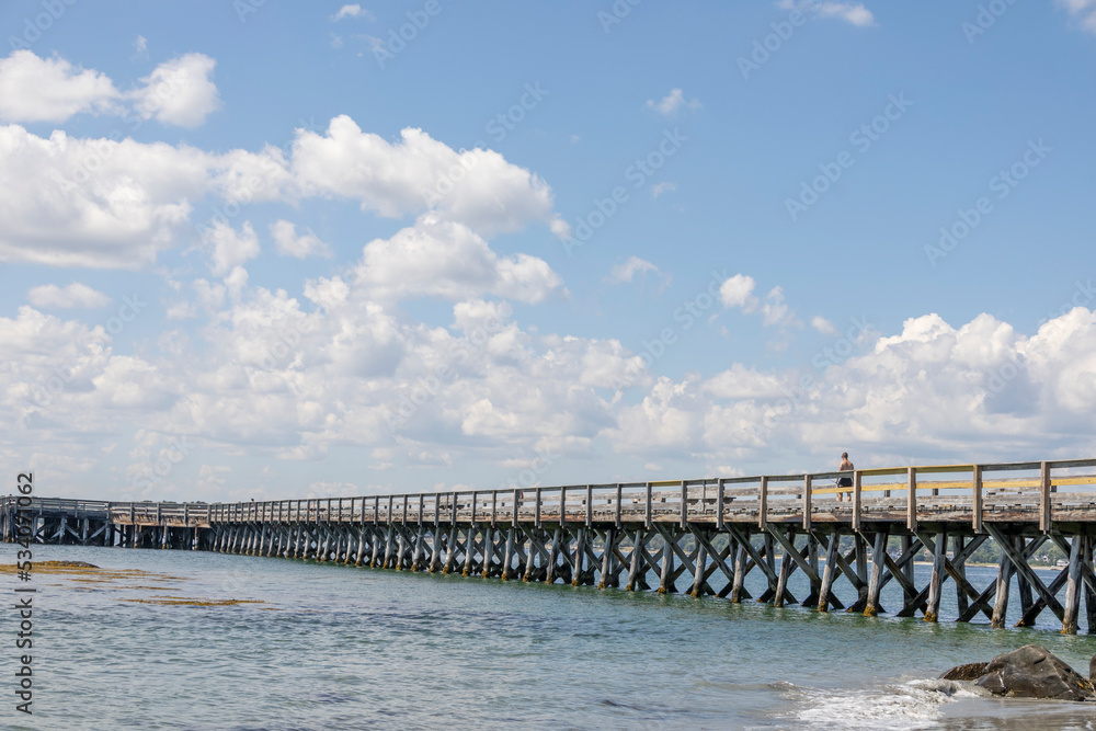Wooden pier by the beach and ocean in the summer