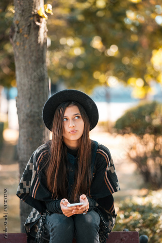 Young woman on a bench in the autumn park