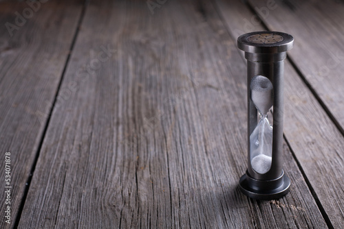 Hourglass on dark wooden background with copy space