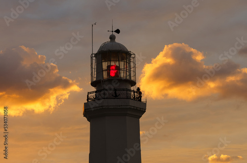 Burning lighthouse against the background of the twilight sky.
