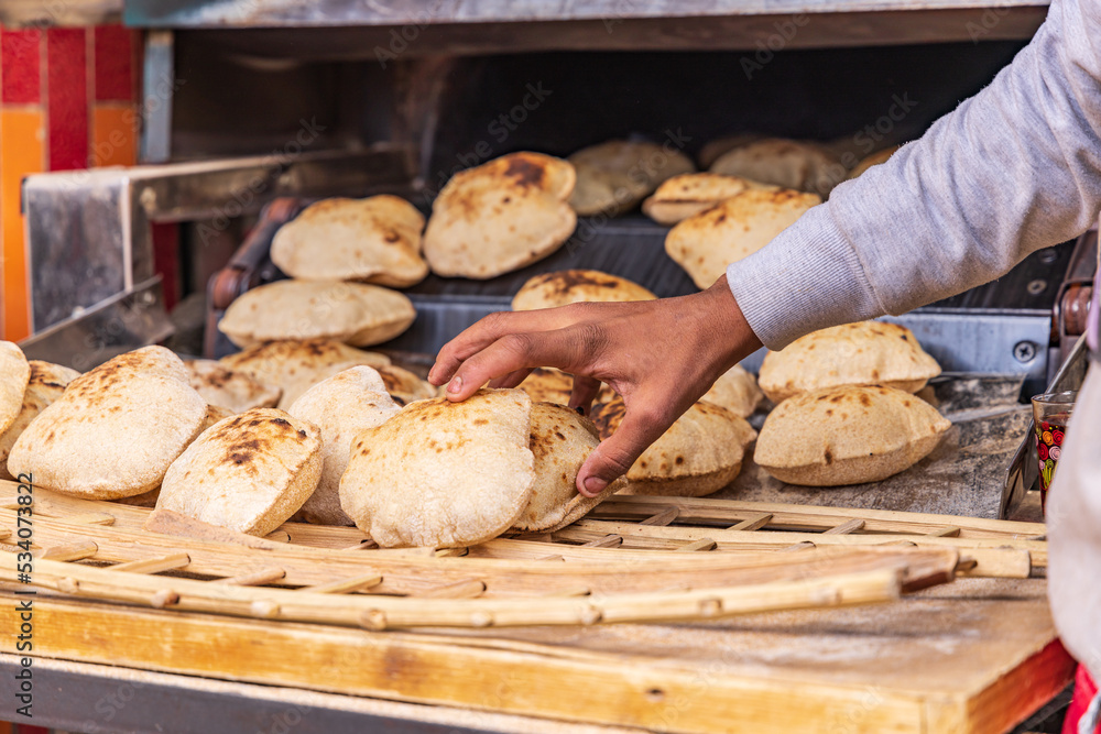 Baker making fresh pita bread, known as aish, in Manshiyat Naser, Garbage City, Cairo. Baker making fresh pita bread, known as aish, in Manshiyat Naser, Garbage City, Cairo.