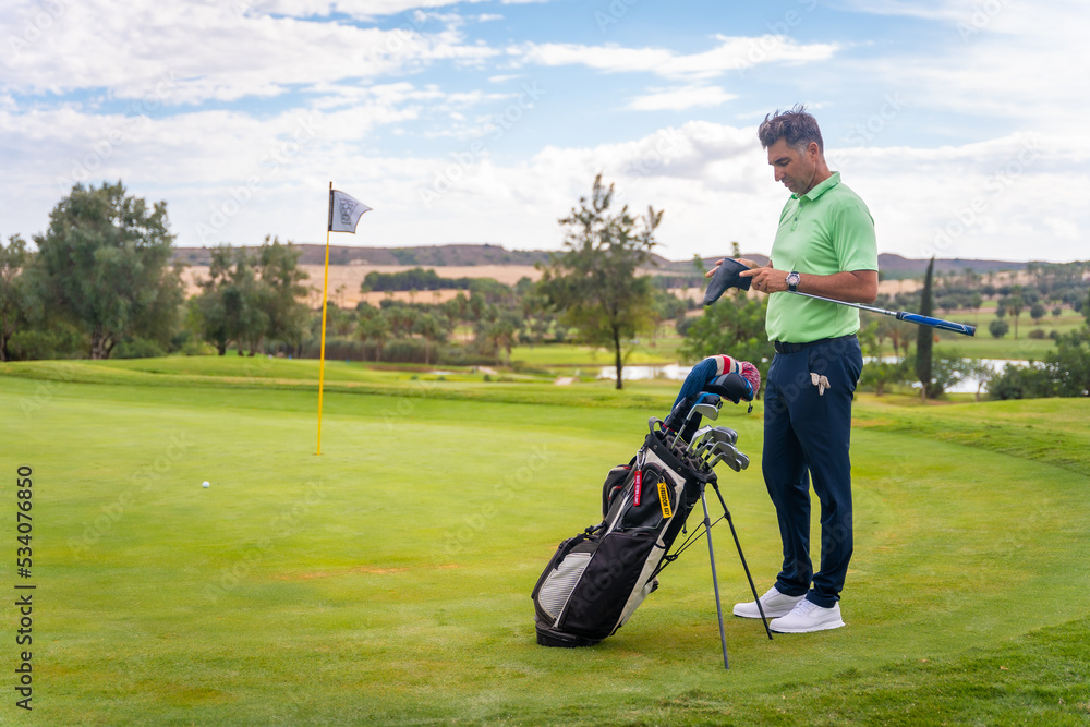 Caucasian professional golf player on the green preparing for the shot Caucasian professional golf player on the green preparing for the shot