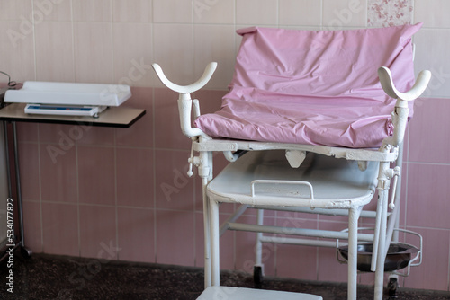 Image of old pink gynecological chair in toffice room professional clinic with copy space. Pregnancy Planning parturition lying-in maternity pain obstetrics Concept photo