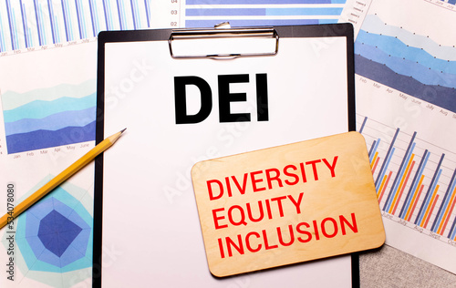 wooden blocks with text DEI on yellow background. dei - short for diversity equity inclusion photo