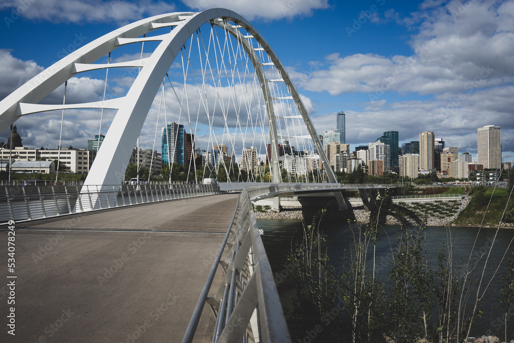 Fototapeta premium Close-up of suspension bridge during the day with Edmonton, Alberta, Canada skyline in background