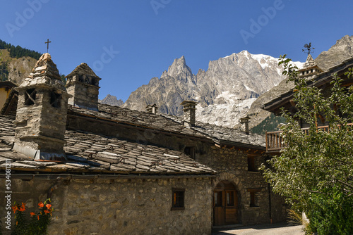 The alpine village with the Aiguille Noire de Peuterey peak of the Mont Blanc Massif in the background in summer, Entreves, Courmayeur, Aosta Valley, Italy