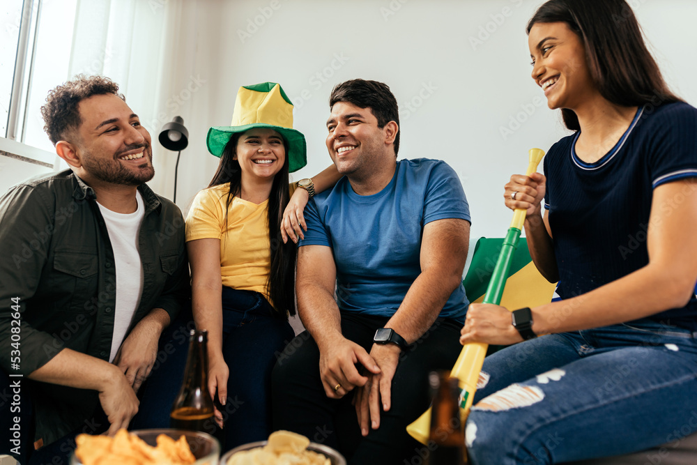 Obraz premium Football fans friends watching Brazil national team in live soccer match on TV at home