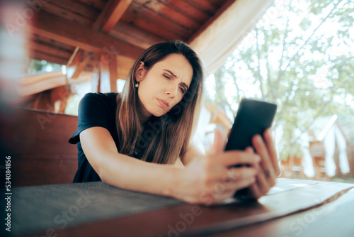 Woman Squinting Trying to Read Small Text on her Phone. Lady suffering from presbyopia aging vision problems 
 photo