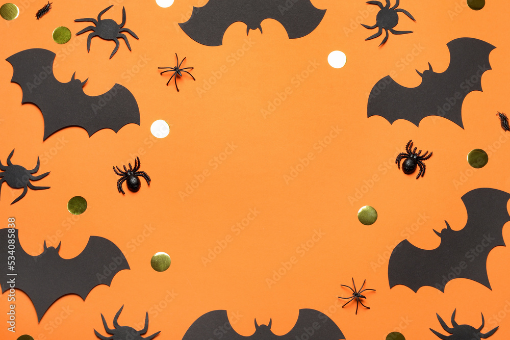 Frame made with Halloween decor on orange background, flat lay. Space for text