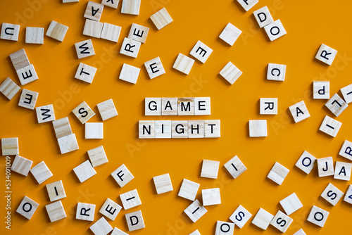 Letter tiles board game on orange background with words Game Night