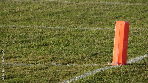 End zone pylon at high school football field during late afternoon photo