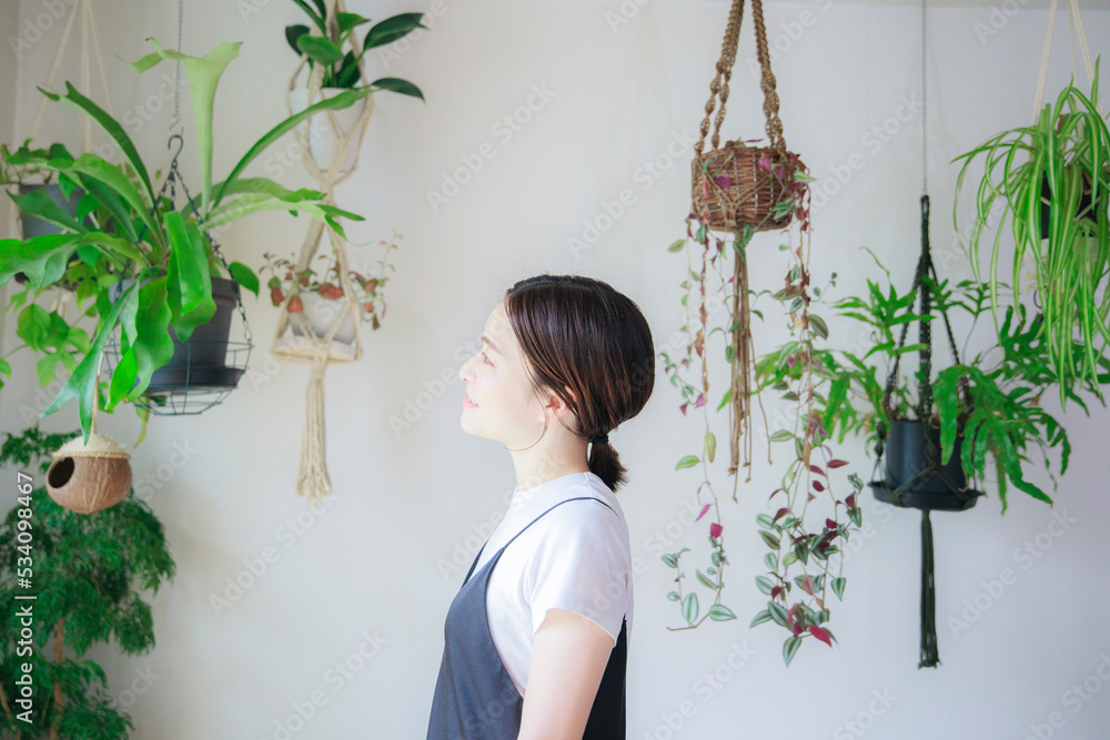 明るい植物のある室内で佇むの日本人女性 明るい植物のある室内で佇むの日本人女性