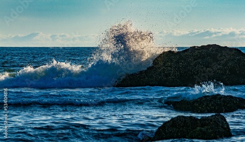 Ocean waves crashing into the big rocks on Cannon Beach, Oregon photo