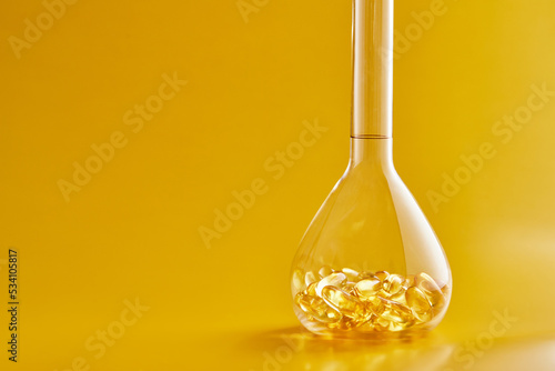 Omega-3 fatty acid capsules on a blue background in a flask. The concept of medicine and healthy living. Front view.