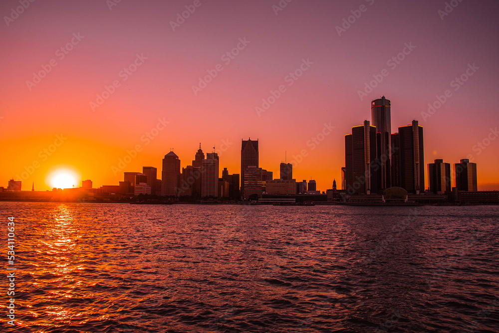 View of the skyline of Downtown Detroit, Michigan from across the Detroit river at the Windsor, Ontario riverfront at sunset
