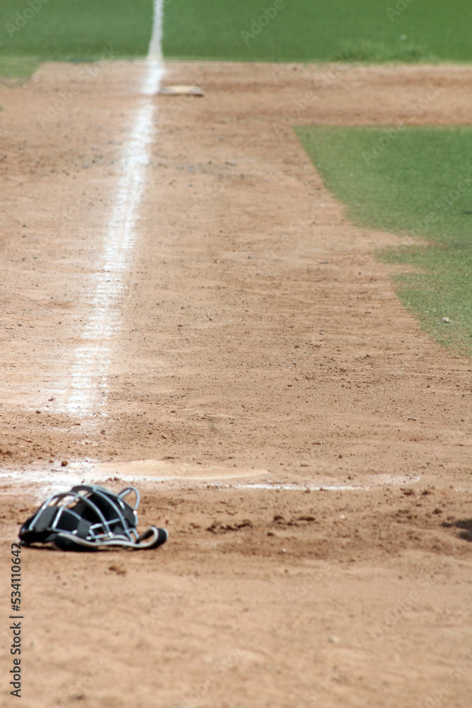 catcher's mask lying on the field at an afternoon baseball game