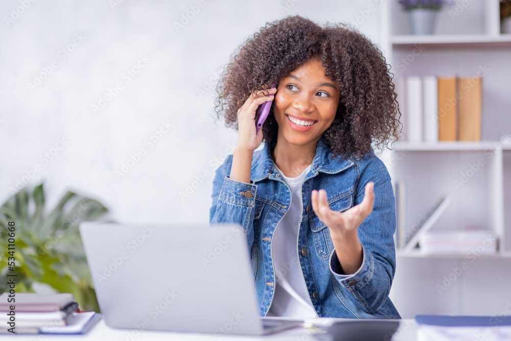 Cheerful business african american lady talking on the phone when using laptop, african Female Entrepreneur Talking On Phone Working On Laptop Empty Space.
Cheerful business african american lady talking on the phone when using laptop, african Female Entrepreneur Talking On Phone Working On Laptop Empty Space.
