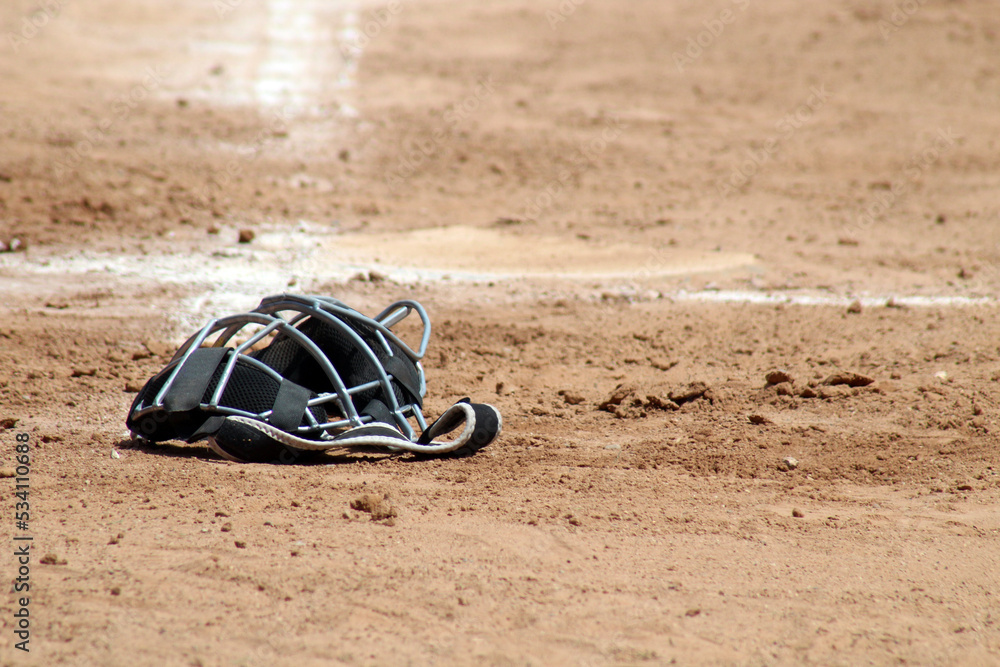 catcher's mask lying on the field at an afternoon baseball game