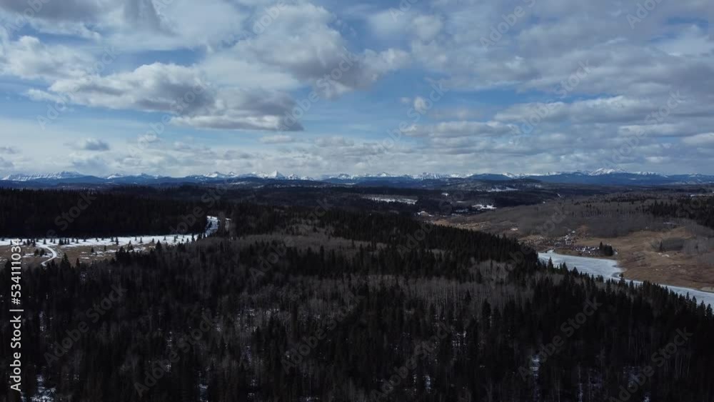 Drone straight up shot revealing mountains on background in early spring forest area Drone straight up shot revealing mountains on background in early spring forest area
