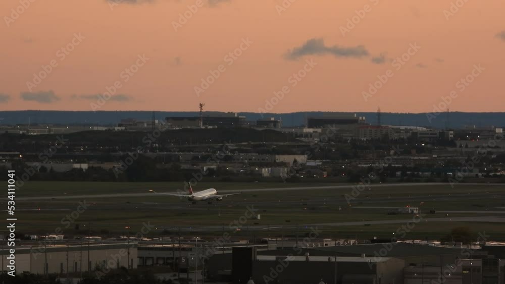 Commercial plane on airport runway taking off and flying in orange sky with rising sun Commercial plane on airport runway taking off and flying in orange sky with rising sun