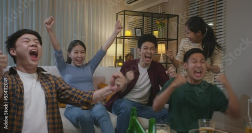 Group of young adult friend man and woman asia people sit at sofa couch joy night party fun game match world cup live TV at home eat snack bowl drink beer bottle glass jump mad happy win exult face
