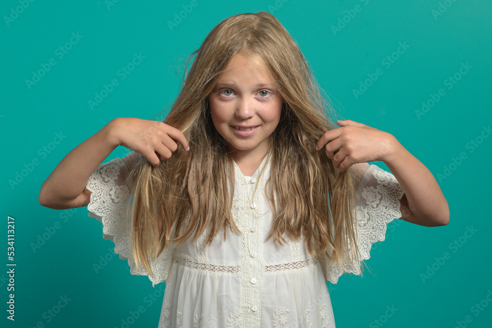 Time for the hairdresser. Teenage girl with long hair. Close-up on a green background Time for the hairdresser. Teenage girl with long hair. Close-up on a green background