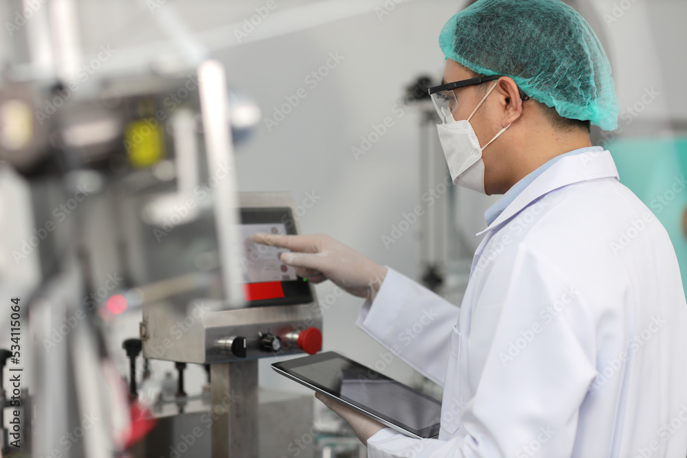 Worker in personal protective equipment or PPE inspecting quality of mask and medical face mask production line in factory, manufacturing industry and factory concept. Worker in personal protective equipment or PPE inspecting quality of mask and medical face mask production line in factory, manufacturing industry and factory concept.