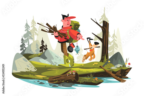 Man collecting brushwood for campfire with dog
