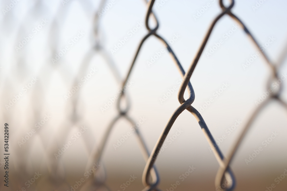 Fototapeta premium Closeup of chain link fence. Mesh netting on gray background