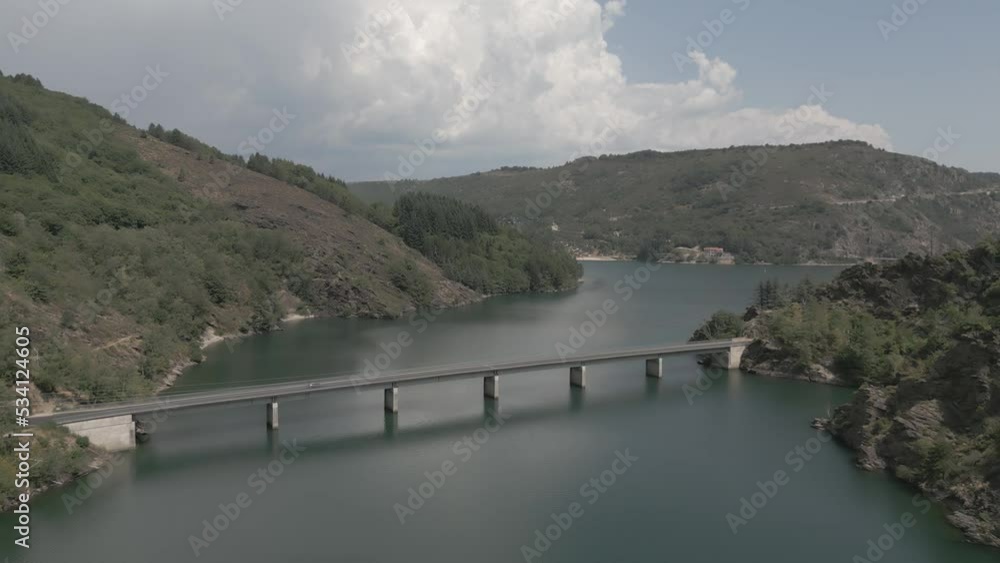 Dolly forward drone shot above a nice brige over Villefort lake with car crossing Dolly forward drone shot above a nice brige over Villefort lake with car crossing